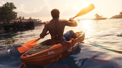 A shirtless man paddles an orange kayak marked Crest across flat water into a low sun.