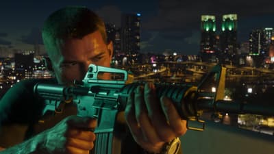 A man shoulders a short M4-style carbine on a rooftop at night, lit office towers glowing behind him.
