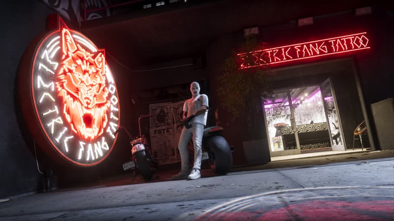 A tattoo parlour front at night lit by a neon fanged animal head above the Elektrik Fang sign.