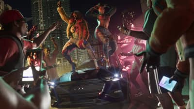 Two performers dance on a car hood ringed by a crowd holding up phone cameras.