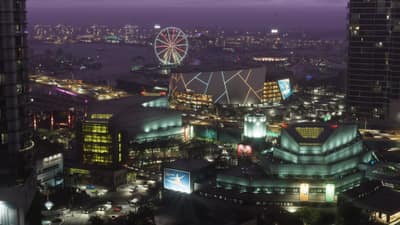 Night aerial over downtown Vice City, a lit ferris wheel and tower blocks along the water.