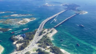 Long bridge carrying traffic across turquoise flats between mangrove islets