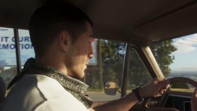 Jason at the wheel of a pickup on a sun-bleached road, roadside billboard behind
