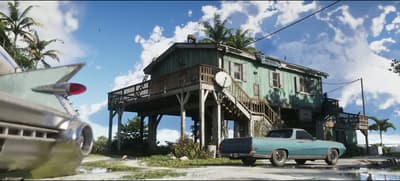 Weathered green stilt house on pilings above a Keys shoreline, classic car parked below