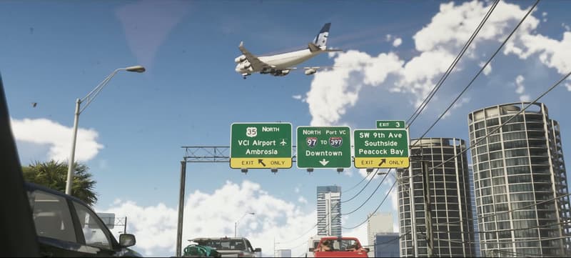 An airliner drops in over a freeway gantry signed for VCI Airport and Ambrosia