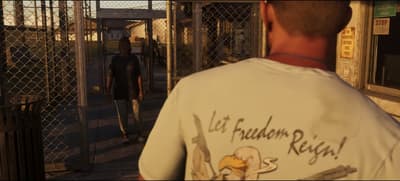 A “Let Freedom Reign!” eagle print on Jason’s back as he waits inside the prison gate