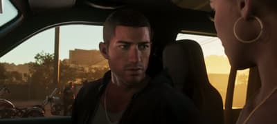Jason turning to look back from the front seat of a car in low evening light