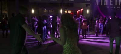 Packed nightclub dance floor under a purple-lit Vice City sign