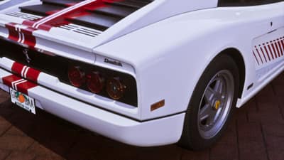 Rear of a white sports car badged Cheetah with triple round tail lights and a Leonida plate.