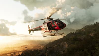 A red and white news helicopter banks over forested hills at sunset.