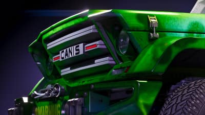Close-up of a bright green pickup's chrome grille and Canis badge against a dark backdrop.