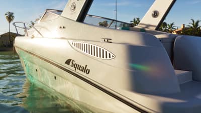 The white hull of a Squalo speedboat, its name decal catching low sun on calm water.