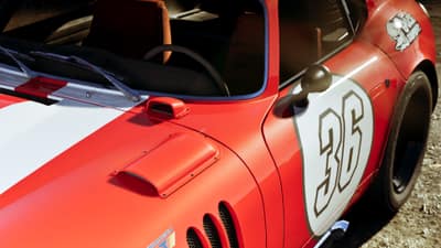 The flank of a red and white race-liveried coupe carrying the number 36 on its door.