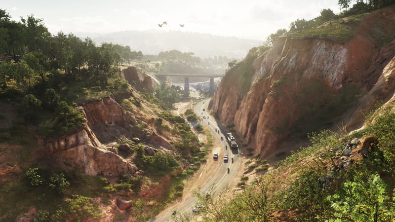 A two-lane road winds through a red rock canyon toward a bridge, a big cat crouched on the ridge at right.