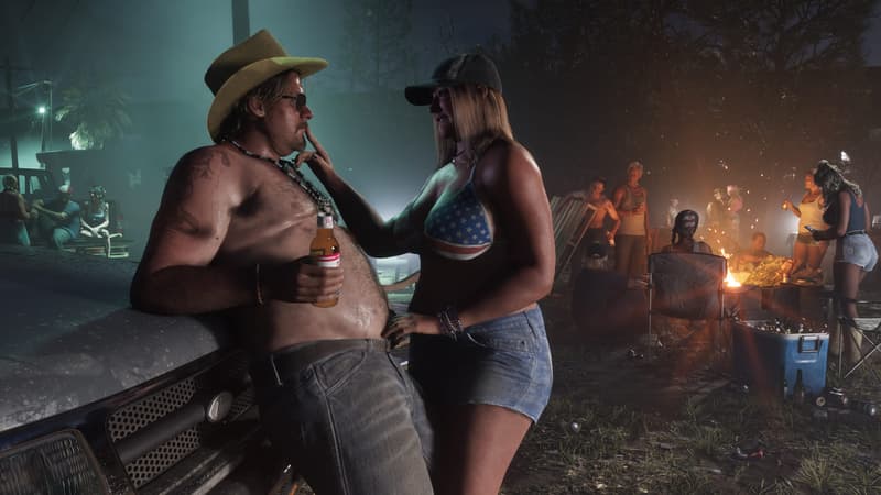A shirtless man in a cowboy hat holds a beer against a truck hood while a bonfire cookout carries on behind.